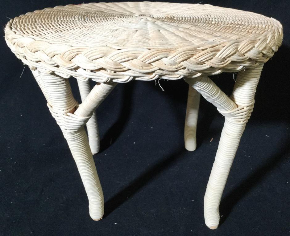 Cream Toned Wicker Footstool: Piece has a tan cream tone. Stool has 4 legs. Top of piece is round. Piece measures approx 12 inches wide 10 inches tall. foot stool, foot rest, plant stand 6