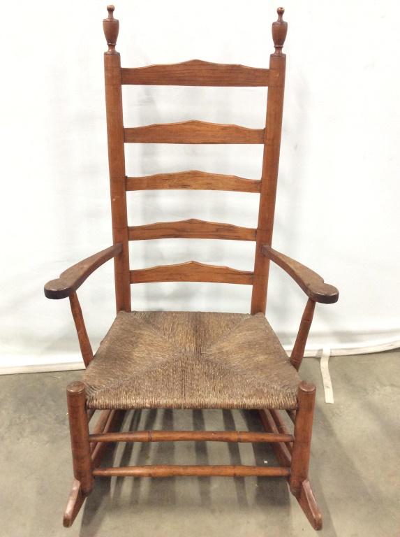 Vintage Wooden Ladder Back Rocking chair: Rocking chair, Vintage and wooden. Piece has a ladder style backrest. Piece has carved wooden finials at top of backrest. Chair has Rush Seat. Rocking chair, wooden rocking chair, vintage rocking chai
