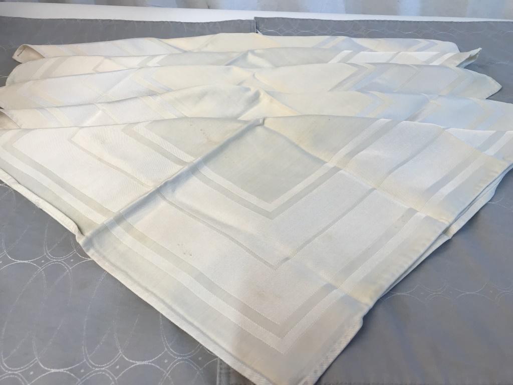 Lot 9 Table Linens: Set 4 grey padded cotton/ poly placemats by Waterford Linens. Some blemishes. 19 x 12 in. Set 5 Cream Cotton / Rayon Dinner Napkins. 18.5 x 17.75 in. Some blemishes. Napery, Cloth, Textiles, Cotton, R
