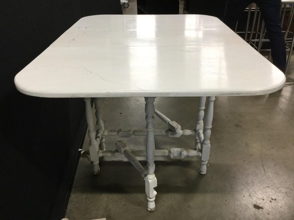 Vintage Carved Wooden Drop Leaf Table: Table is white toned and wooden. Piece contains 2 drop leafs. Piece is Possibly Hand Crafted. Table vintage. Piece measures approx 48 inches long 34 deep 30 inches tall when fully open. Dining table,