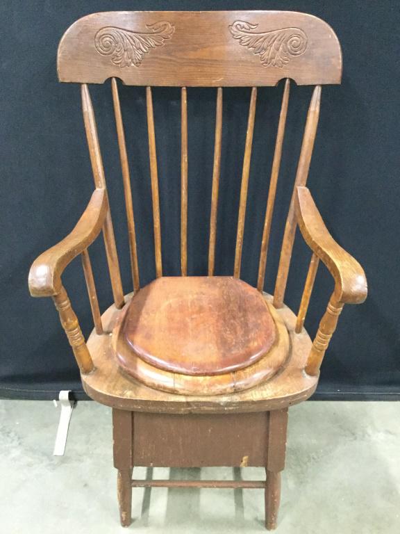 Antique Carved Wooden Commode Chair: Chair is vintage possibly antique. Piece has carved wooden detail. Piece has spindle backrest. Piece has toilet seat lid. Top of backrest has Carved Relief Detail. Piece measures approx 41inches tall 