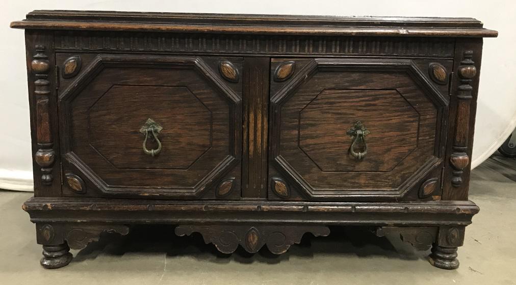 Vintage Carved Wooden Low Cabinet Coffee Table: Vintage Carved Wooden Low Cabinet Coffee Table, carved design on front and front feet, doors that open to reveal lower storage and two metal door pulls on hinges, chips, scratches and some damage in a