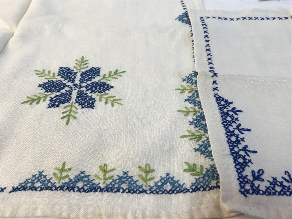 Collectible Cross Stitched Embroiderd Tableware: Set 5, Vintage, cross stitch embroidery by hand. Tablecloth with blue floral sand border. 33.5 x 32 in. Matching dinner / lunch napkins with navy blue embroidery. One light mark on one napkin, some st