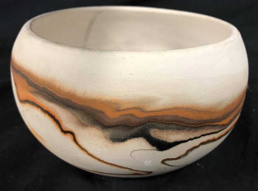 Handmade NEMADJI POTTERY Bowl: Underside of piece reads NEMADJI POTTERY HANDMADE HANDPAINTED. Piece appears to be ceramic. Piece contains tones of orange, black, brown and cream. Ceramic bowl, ceramic pottery. tableware, tabletop a