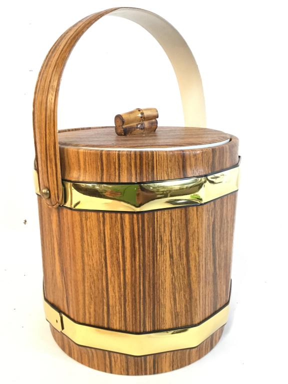 Lidded Ice Bucket W Lid & Wood Print Covering: Ice bucket is Lidded. Piece has handle. Bucket has wood style covering and old toned detail. Piece measures approx 12.5 inches tall with handle 8.5 inches wide. ice bucket, barware, picnic accessory,