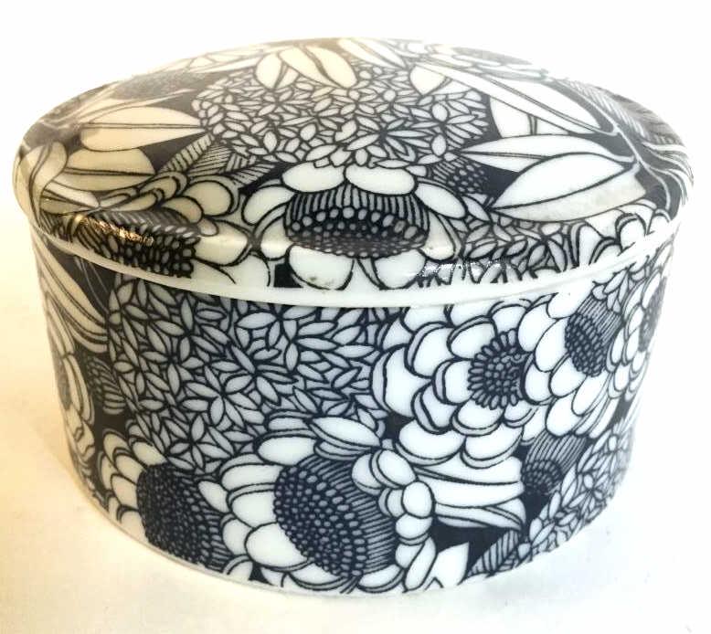 Lot 2 Porcelain and Metal Trinket Boxes: Trinket Boxes are porcelain. One appears to be hand painted. 1 depicts a female figure, 1 has blue and white toned floral detail. Larger box measures approximately 3 inches wide 2 inches tall. Smaller