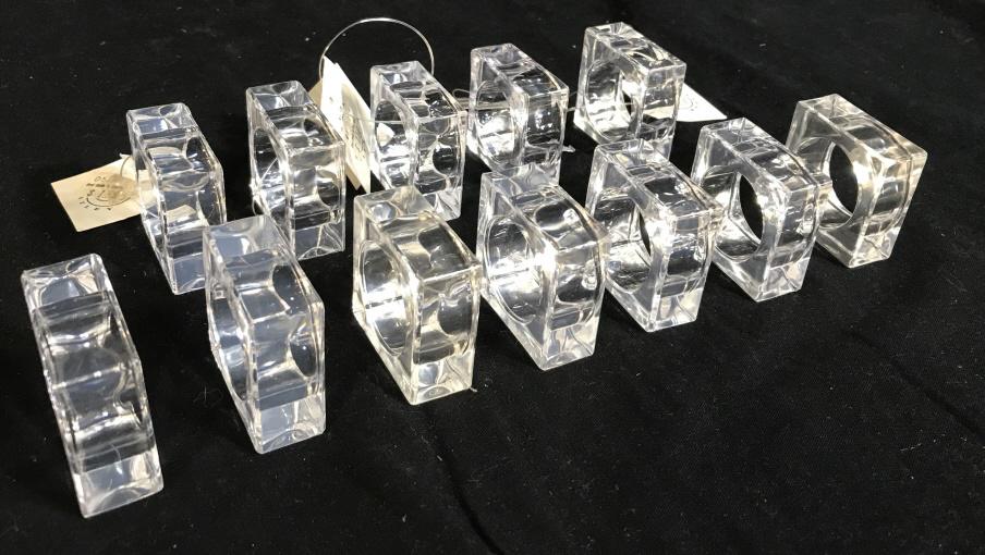 Lot 12 Lucite Napkin Rings, Designer Kemp Beatley: Square Translucent Lucite with round center Napkin pass- through. Half still have original tag, from Bed, Bath & Beyond. 1 3/4 in. squared. Pass through diameter, 1 in. Napery Accessory, Lucite Napkin