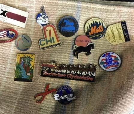 Lot 23 assorted vintage collectibles and pouch: Lot contains assorted collectibles ranging from pins, to coins, to keychains. Notable items include Olympic pins and Olympic keychain. Pouch has various pins attached to it. Constructed from secure ma