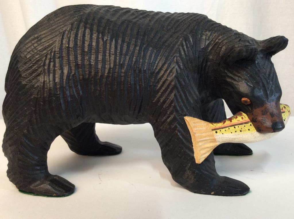 Carved Wooden Folk Art Black Bear Sculpture: Carved Wooden and painted folk art art black bear tabletop sculpture with fish in Its mouth. Measures approx 7.5 inches in height by 12 inches in length by 6 inches in width. Green felt lining pads un