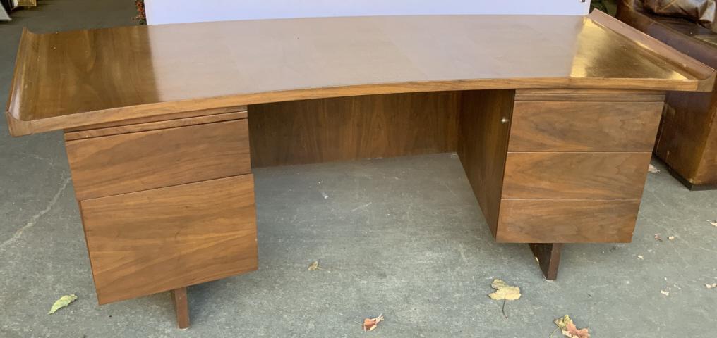 Harvey Probber Curved Walnut Top Executive Desk: Rare rolled edge and curved top executive desk. Manufactured by Arnold Furniture, with label on exterior of top left drawer. Measures approx 30 inches in height by 84 inches in width by 35 inches in d