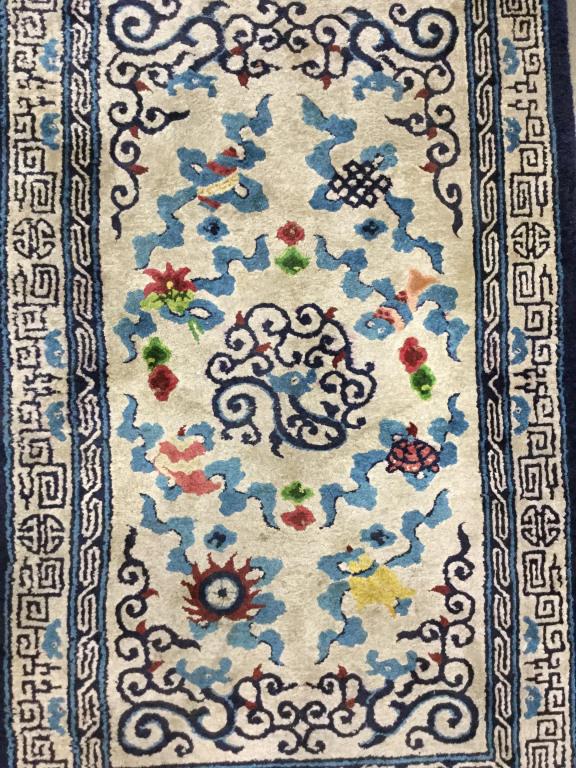 Vintage Handmade Chinese Art Deco Rug: Rug is vintage possibly antique. Piece is handmade and wool. Rug contains fringes. Contains multi toned floral floral leaf and geometric detail with tones of blue, yellow, coral, red, and green. Measu