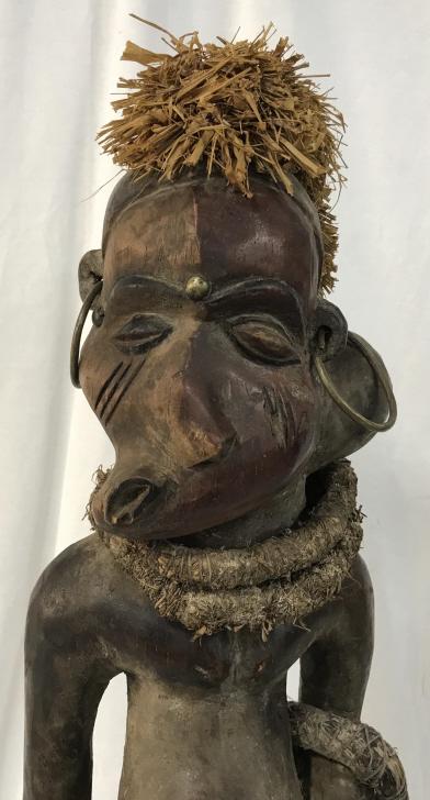 African Art Fetish Pende Wooden Figural Sculpture: African Art Pende fetish figure for curing of sickness and disease, from Zaire, Congo. Carved wooden sculpture has raffia details as hair and bracelets. Figure has brass bead in forehead and as belly 