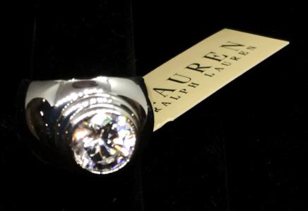 Solitaire Bezel Set CZ Ring by RALPH LAUREN: SIGNED logo. Round Center Stone, High setting, open Gallery, wide upper shank side band. Attached is designer tag, LAUREN Ralph Lauren Collection. Brilliant Shine, Everyday or Holiday Fashion. Size 8.