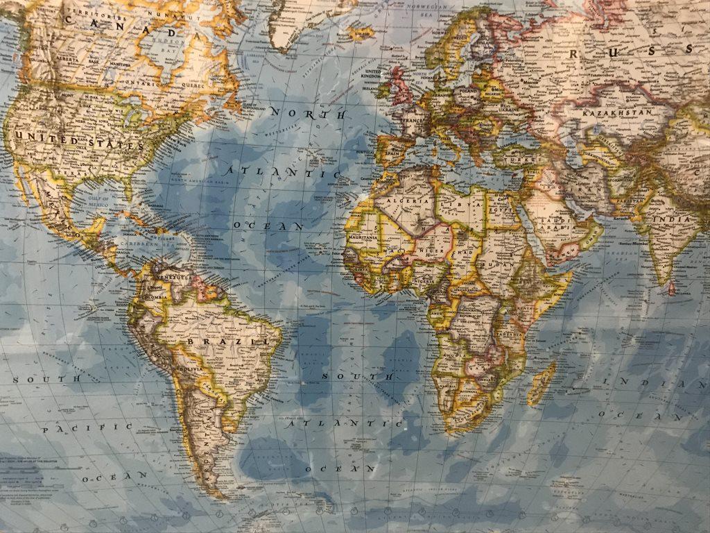 Oversized Framed Poster, Nat Geo’s World Atlas: Framed poster print of the world map by National Geographic. Copyright 2000. Poster is set behind plexiglass in black tone metal frame. Measures approx 48.25 inches in height by 69.5 inches in width w