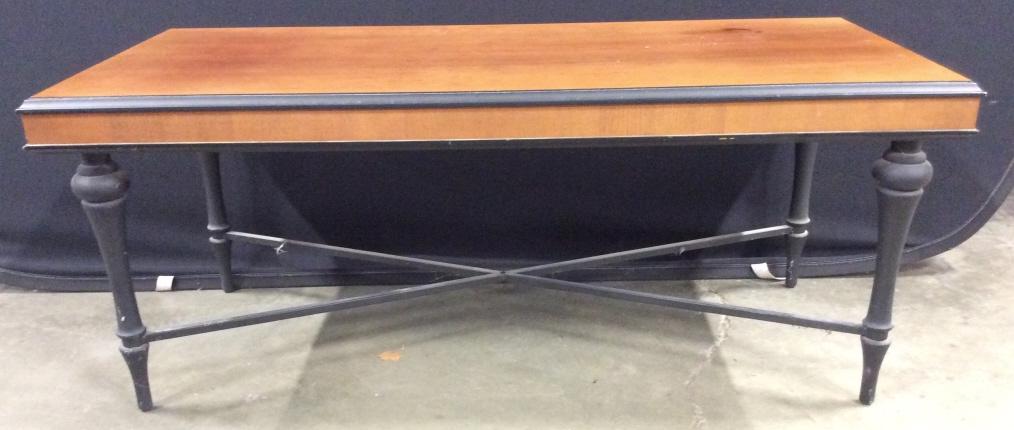 THE BOMBAY COMPANY Wooden Coffee Table: Underside of tabletop is marked THE BOMBAY COMPANY. Piece has tones of black, & saturated beige. Piece has 4 carved wooden legs. Piece measures approx 45 inches long 19 inches tall 21 inches deep piec