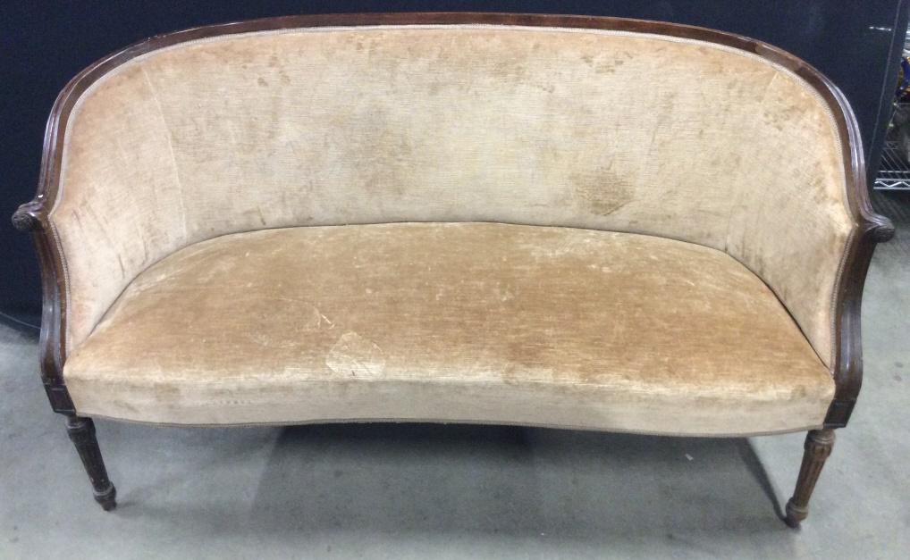 Setee Tan Toned Carved Wooden Upholstered Loveseat: Loveseat is tan toned. Frame is brown toned with carved wooden detail Measures approx 57 inches long 32 inches tall 24 inches deep. Contains some scratches, wear, and stains. loveseat, home furnishing