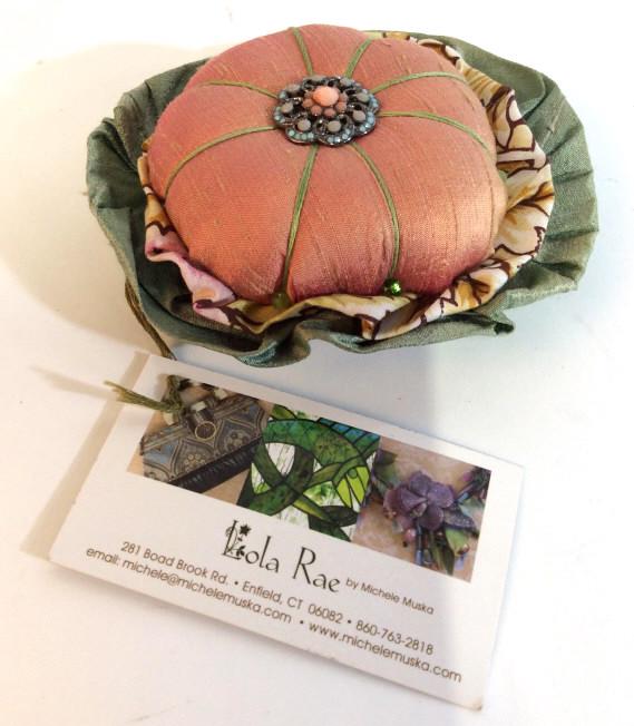 Handmade Silk Pin Cushion, Designer Michele Muska: Vintage Style Pin Cushion with center beaded ornament. Silk & Cotton fabrics, with original tag, labeled ‘Lola Rae by Michele Muska’ , a Designer based in Enfield, CT. Pin cushion section 3 1/4 in
