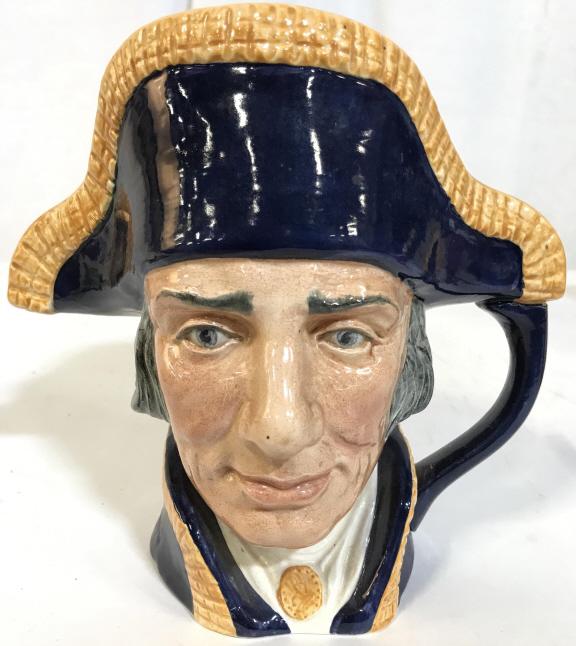 ROYAL DOULTON LORD NELSON Porcelain Mug: Underside is marked ROYAL DOULTON LORD NELSON. Piece depicts a male figure head wearing a hat. Piece measures approx 7.5 inches tall and wide. Piece appears to be hand painted. With handle. Piece has 
