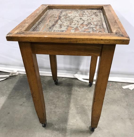 Vintage Wooden Side Table On Casters: Table is wooden. Piece sits on 4 black toned casters. Piece measures approx 22 inches tall 21 inches long 16inches wide. side table, end table, home accent and accessories 6
