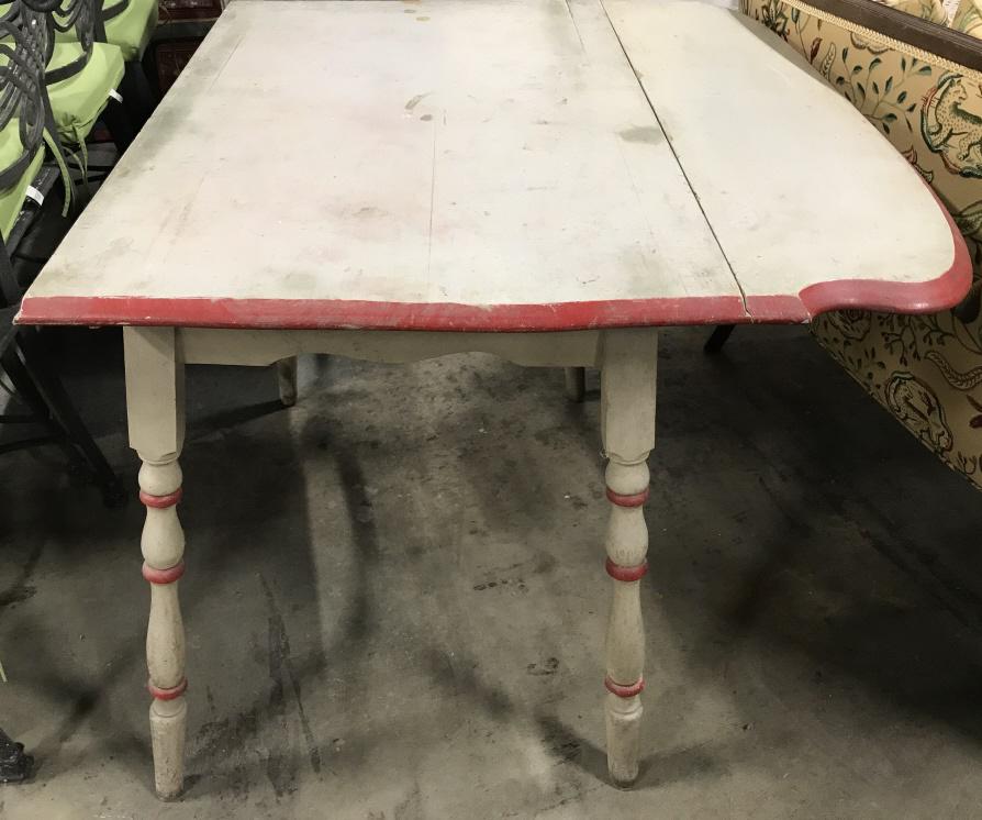 Vintage Carved Wooden Drop Leaf Table: Table is slate toned and red toned. Piece has 1 drop leaf. Piece has carved wooden legs. Measures approx. 36 inches long 29 inches tall 27 inches wide when fully open contains evident cracks & wear. d