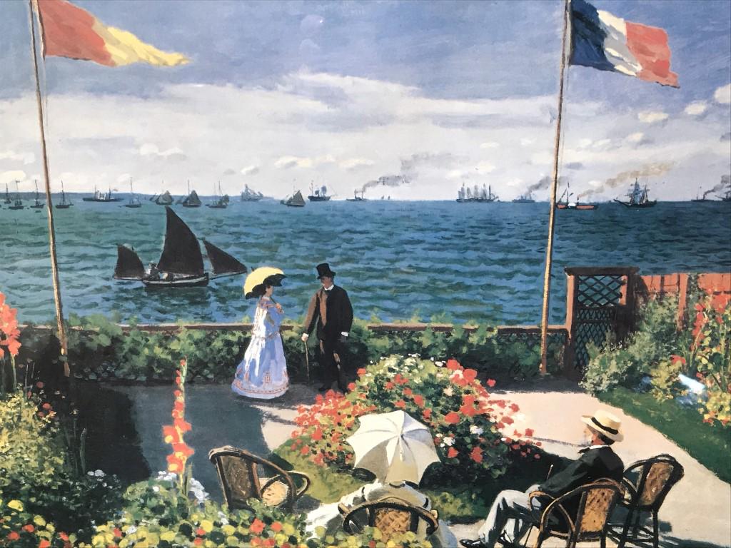 Framed Monet Print, Garden at Sainte-Adresse: Monet Print depciting Garden at Saints-Adresse, set behind acrylic in gold tone wood style frame. Measures approximately 17.5 inches in height by 21.5 inches in width with frame, minor blemish in fram