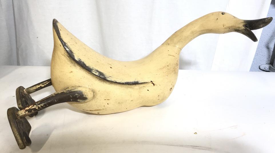 Wooden Folk Art Reclining Duck: Wood Duck painted over in cream, sculpted and laying on belly. Seems to have been repaired, he can’t stand on his web feet. 17 in long by 4 1/4 in wide. Dried glue material on bottom of one foot, po