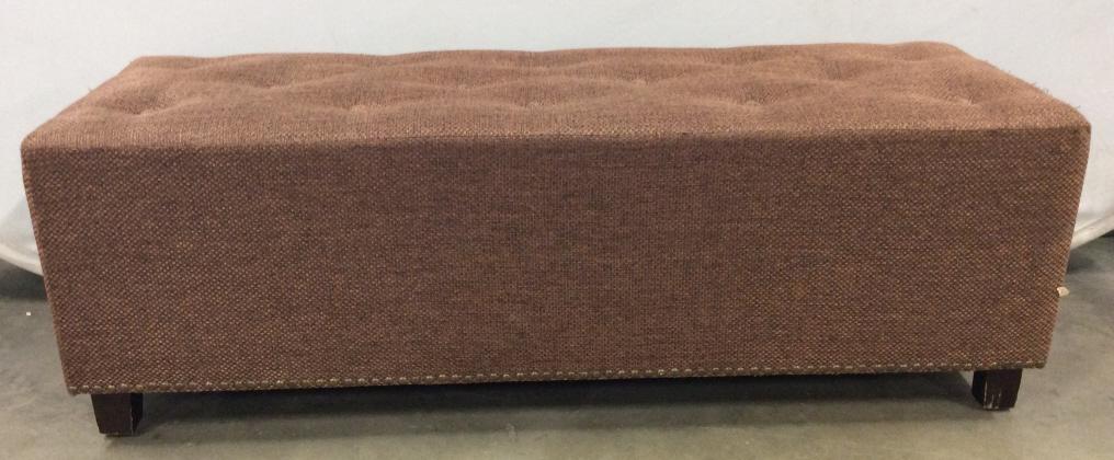 Footed Upholstered Tufted Bench: Bench has a light chocolate tone. Top of piece is tufted. Bench has 4 brown toned wooden feet. Piece also has gold toned nailhead detail. Piece measures approx 47 inches long 16 inches tall and deep. 