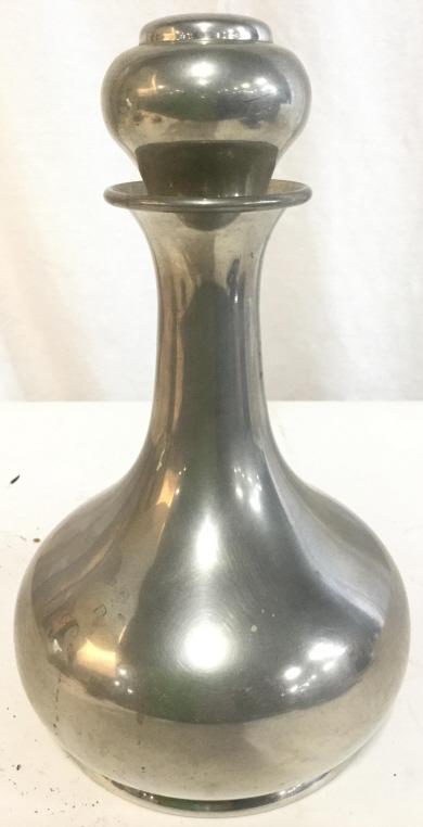 Silver Toned PEWTER Decanter W Stopper: Decanter is silver toned. Piece is pewter. Decanter includes stopper. Piece measures approx 10 inches tall 6 inches wide. Underside is marked PEWTER. decanter, barware, shelf peice, decorative arts an