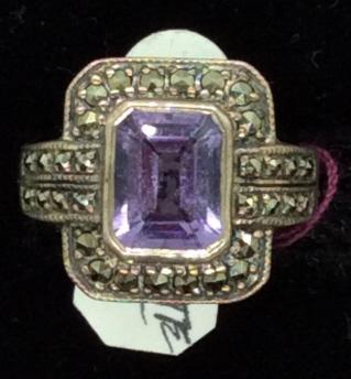 Amethyst Center & Marcasite in SS: Size 6 Sterling Silver Ring has antique Art Deco style with emerald cut center stone ( 7x 9 mm) that tests positive for Amethyst. Clean and elegant in bezel setting with marcasite rhinestones surround