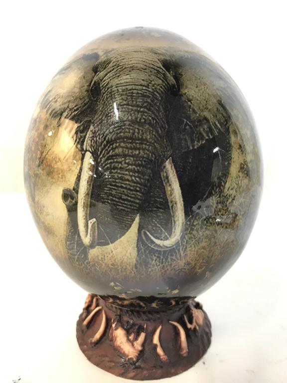 Decorative Ostrich Egg W Stand: Ostrich egg has digital print depiction of elephant. Lot includes stand which appears to be ceramic. When put together piece measures approximately 6.5 inches tall 5 inches wide. Piece appears to have