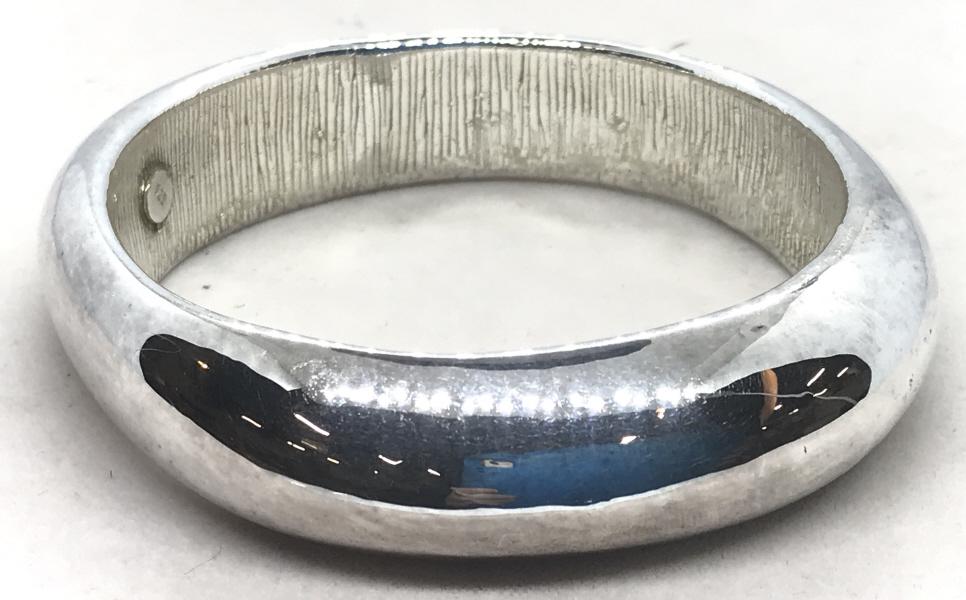 Sterling Silver Art Form Bangle: This SS BANGLE has A Smooth Exterior Finish, rounded and 7/8 in wide. Etched straight line design on underside. Shape is not a perfect sphere, giving it a unique artistic style. Labeled . 925 on silve