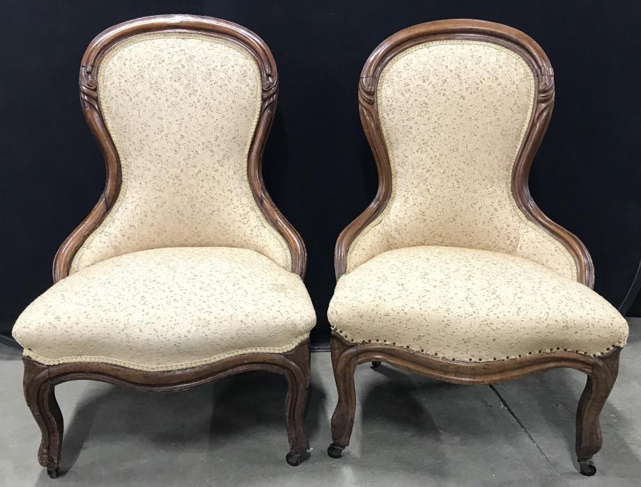 Pair Antique Victorian Slipper Chairs: Pair Antique Victorian Slipper Chairs With carved wooden frame and textures upholstery on caster feet, some marks to upholstery and trim missing at base of one chair, some small nicks and scratches to