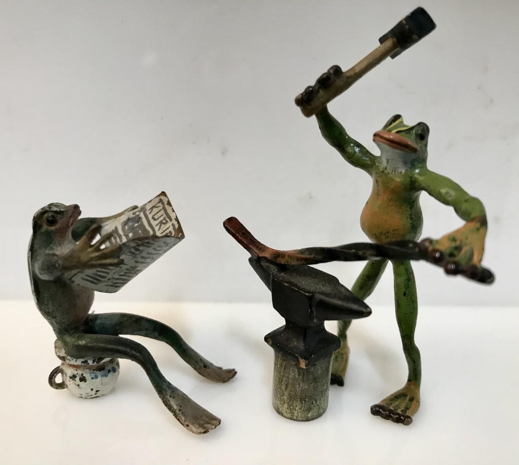 Lot 2 Antique Vienna Bronze Miniature Frogs: Lot 2 antique Cold-Painted Vienna Bronze miniature frogs, c. 1910, anthropomorphic and whimsical in style. 1 frog figurine is a blacksmith hammering an iron rod, the other is sitting ‘on the can’ 