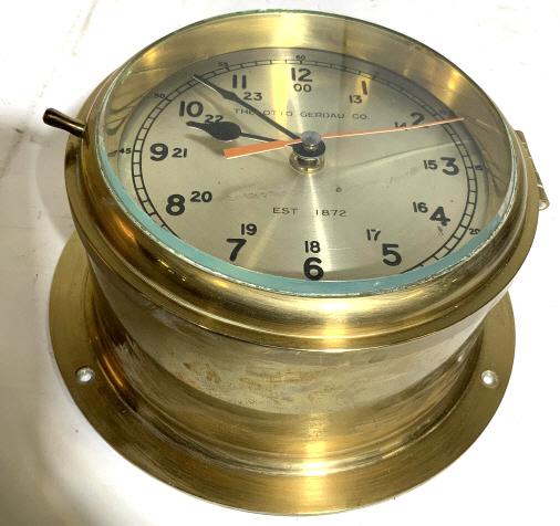 The Otto Gerdau Co. Brass Ships Bell Clock: Very heavy Brass Ships Bell Clock marked for Otto Gerdau, diameter app 9 inches, brass housing, metal face plate, red second hand sweep, measures diameter app 9 inches depth app 4.5 inches, wall mount
