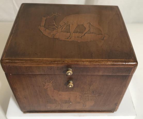 Keepsake Wood Box, Buck Deer Motif: Wood Box with bras hinges, Bone knobs and Pewter Style Metal Interior Lining. Scenes of a buck grazing, fawn resting and hunting dog. Measures 4.5 in. Tall, 5 3/4 in long, 4 3/4 in. wide. Base has nic