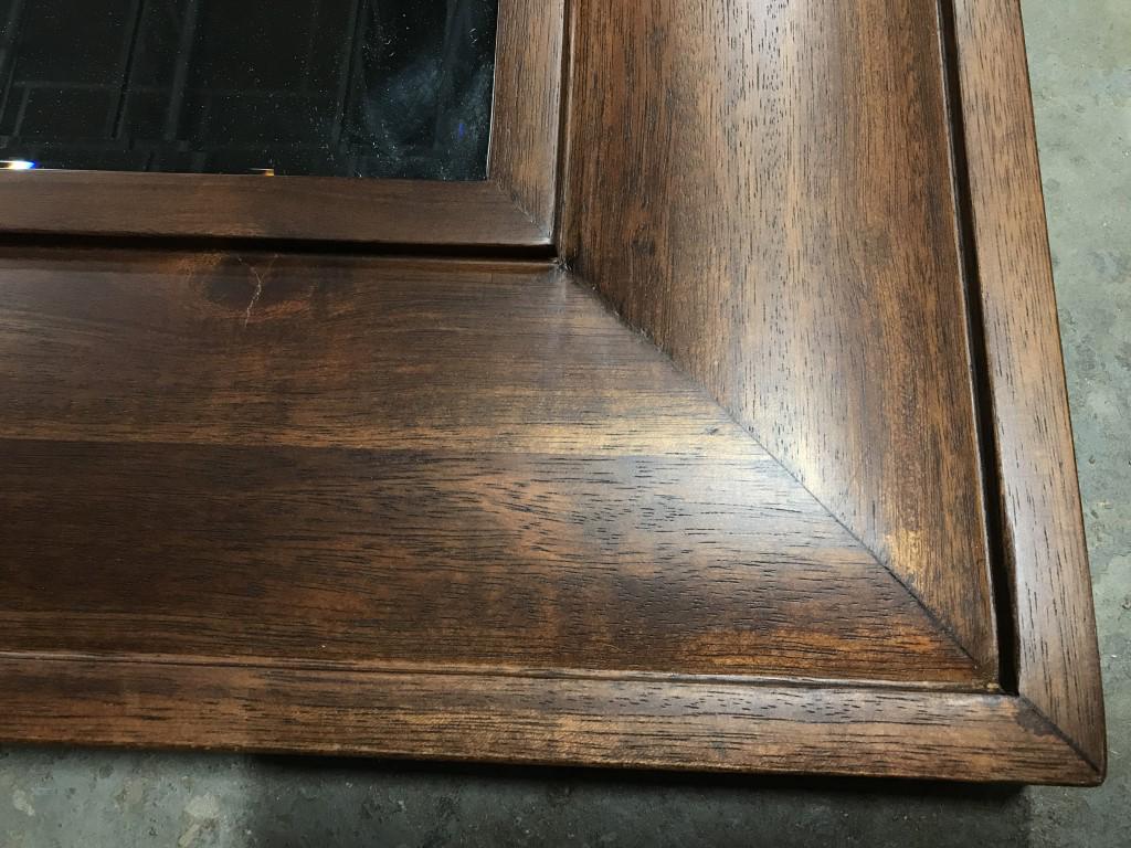 Beveled Mantel Mirror in Wood Frame: Beveled mantel mirror set in wood frame. Verso marked for Pottery Barn. Measures approx 31 inches in height by 38.8 inches in width. There is minor, superficial crack in wood along lower right corner.