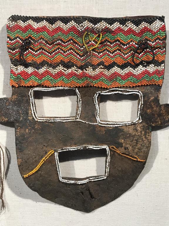 Antique Beaded Hide Mask, Framed: Antique beaded hide mask, possibly African in origin. Hide mask has beaded details throughout, with emphasis on the forehead. Openings in hide for eyes and mouth. Make is mounted on linen and set in l
