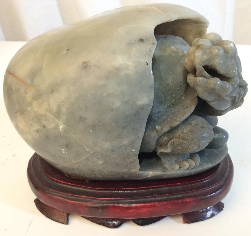 Chinese Soapstone Turtle In Egg On Stand: Sculpture is Soapstone. Piece has a slate green tone. Base is wooden with carved detail. Soapstone Animal, Soapstone Turtle, Turtle sculpture. Piece measures approx 6.5 inches long 4.5 inches tall. as