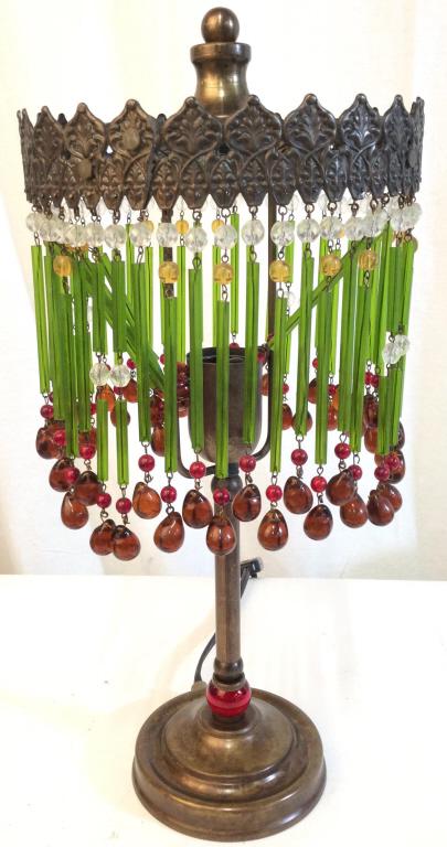 ABC CARPET & HOME Glass Table Lamp: Lamp is glass and metal. Originally purchased from ABC HOME & CARPET. Piece contains hanging decorative glass ornaments with tones of amber, red, green & yellow. Lamp includes finial. Base is circular