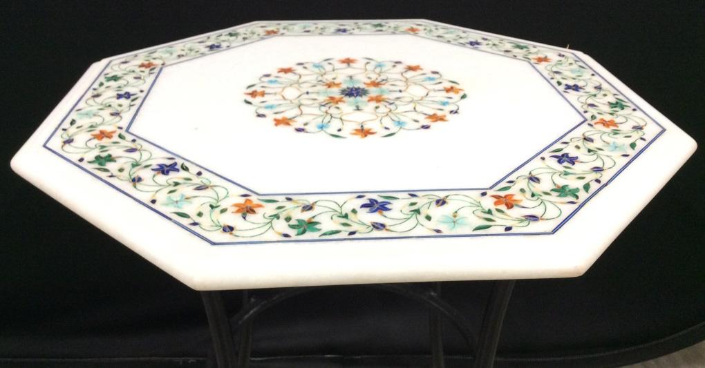 Marble Top Metal Base Side Table: Side table has black tone metal base & Octagon Shaped Top with intricate floral vine and leaf Detail. Table top appears to possibly be marble. Piece measures approx 21 inches tall 20 inches wide. side