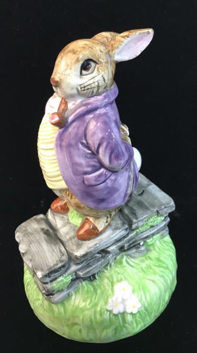 Beatrix POTTER Rotating Porcelain Music Box: Collectible ’Old Mr. Bunny’ Trademarked by Beatrix Potter distributed by Schmid. c. 1980. Mr. Bunny standing on stone wall in a meadow. Painted Porcelain sculptural Figural. 7.5 in. ht. 4.5 in. di