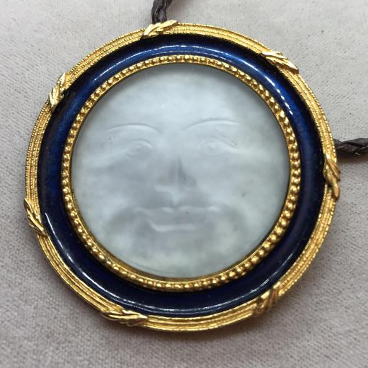 MMA Enamel & Gold Tone Sun Moon Face Pendant: Metropolitan Museum of Art GLASS SUN MOON FACE on Braided Leather cord, adjustable link chain with lobster clasp. Diameter pendant 2 in., center carved face in relief with beaded gold tone metal, blue