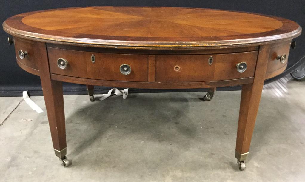 HEKMAN Carved Wooden Coffee Table: Piece reads HEKMAN GRAND RAPIDS on interior. Coffee Table is oval shaped Piece is on casters. 1 drawer handle needs to be re attached. Piece measures approx 42 inches long 29 inches deep 18 inches tal