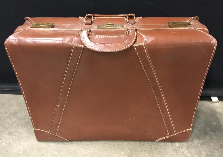 Vintage Brown Leather Toned Suitcase: Vintage Brown Leather Toned, possibly leather, Suitcase With white stitching, brass toned hardware and material lining, measures approximately 18.5 inches tall x 24 inches long x 7 inches deep, scratc
