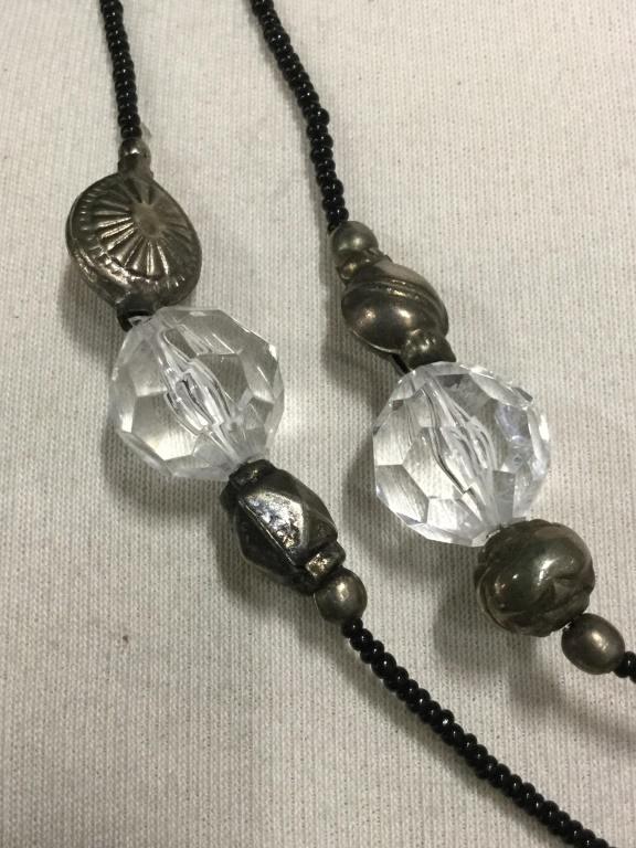 Lot 2 Necklaces, Hematite Beads, Metal Mold Bds: Hematite Beaded Necklace On black string with Tassel, app 15 in. Circumference. Second necklace has seed beads with decorative Repousse metal beads and Composite clear beads. Appears 2 metal pieces da