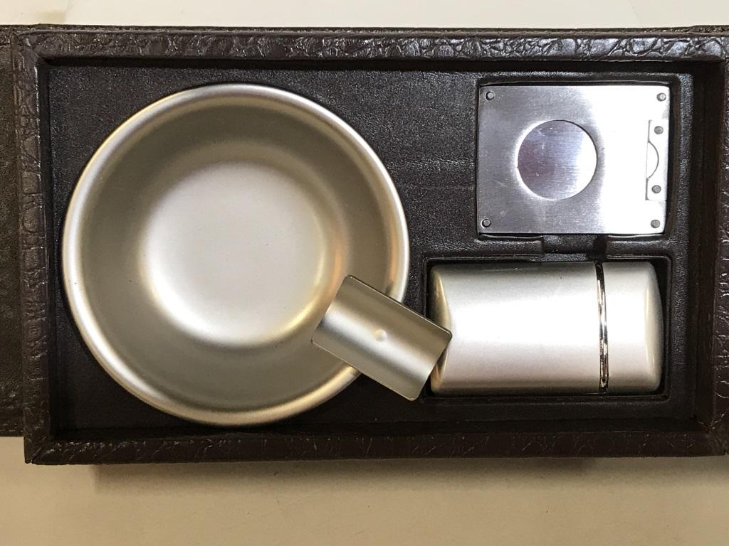 RED ENVELOPE Cigar Kit: Red Envelope cigar kit with case. The kit includes, an ash tray, lighter, and cigar cutter. The compartments within are magnetized to keep the contents in place. The largest piece measures 7.75 H, 4.6