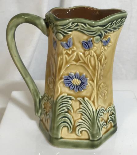 JAY WILLFRED Glazed Ceramic Pitcher: Glazed Ceramic pitcher. Labeled JAY WILLFRED DIU OF ANDREA BY SADEK. Pitcher is decorated in floral sculpting. Glazed ceramic, ceramic collectible, dishware. drinks pitcher collectible, decorative acc