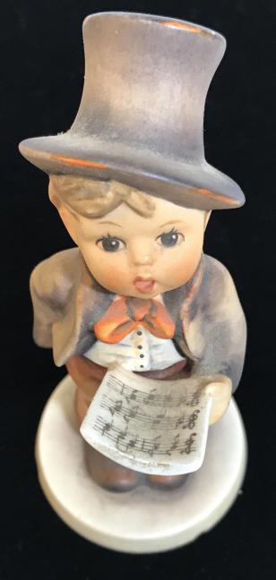 Hand Painted Vintage Porcelain Hummel, Boy Singing: Hummel Goebel Porcelain Figurine, Street Singer Boy w/ Top Hat Holding Music Sheet. Partial Stamp Mark on underside. Can make out traditional ‘Bee’ HallMark. # 131 Also on underside. Measures 5 1/