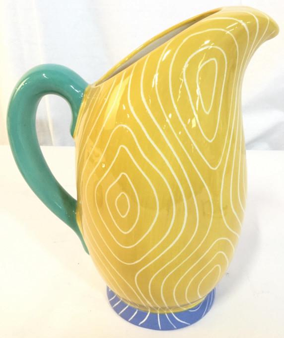 Signed Multi Toned Porcelain Pitcher: Pitcher is signed illegibly on underside. Piece contains tones of teal, yellow, cream & blue. Pitcher, porcelain pitcher, signed pitcher, dinnerware, tabletop accessories. Piece measures approx 10.5 i