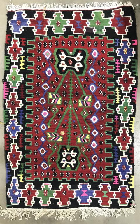 Vintage Multi Toned handmade Wool Rug: Rug is vintage possibly antique. Piece is wool and handmade. Rug contains tones of green, cream, cranberry, purple, blue, black, pink, and yellow. Area rug, wool rug, fringed rug, handmade rug, carpet
